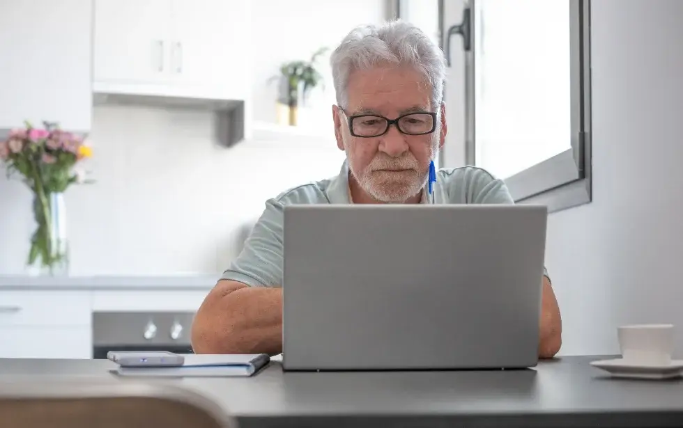 A caregiver joining an online session from his kitchen table